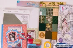 Detailausschnitt mit Mirror Card in Silber, zwei Nellie’s-Choice-Kartensets sowie dem Ciao-Bella-Junk-Journal „Secret Garden“.